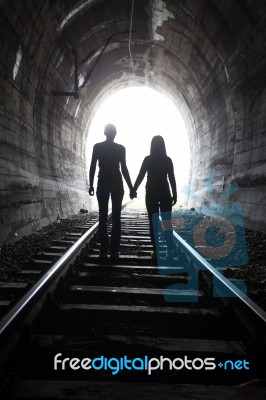 Couple Walking Together Through A Railway Tunnel Stock Photo