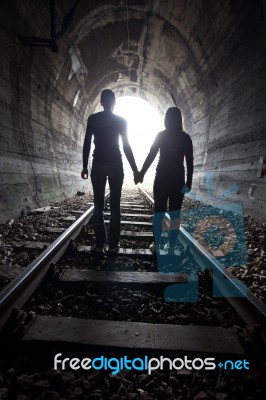 Couple Walking Together Through A Railway Tunnel Stock Photo