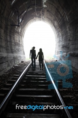 Couple Walking Together Through A Railway Tunnel Stock Photo