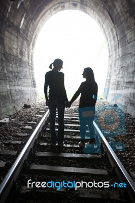 Couple Walking Together Through A Railway Tunnel Stock Photo