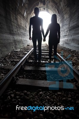 Couple Walking Together Through A Railway Tunnel Stock Photo