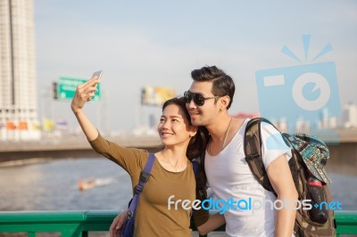 Couples Of Younger Man And Woman Take A Selfie Photograph By Smart Phone On Traveling Location Stock Photo