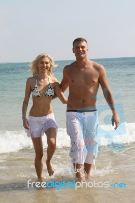 Couples Walking At Beach Stock Photo