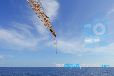 Crane Boom And Crane Hook In The Sea With Sky And Clouds Backgro… Stock Photo