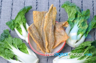 Crispy Fried Salmon Skin And Canton Pak Choi Stock Photo