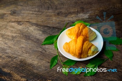 Croissant On Dish With Rice Green Tea Leaves  On Old Wooden Stock Photo