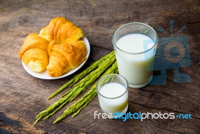 Croissant On Dish With Rice Milk And Ear Of Rice  On Old Wooden Stock Photo