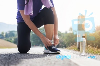 Cropped Shot Of Young Women Runner Tightening Running Shoe Laces… Stock Photo