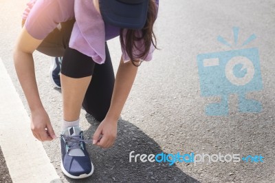 Cropped Shot Of Young Women Runner Tightening Running Shoe Laces… Stock Photo