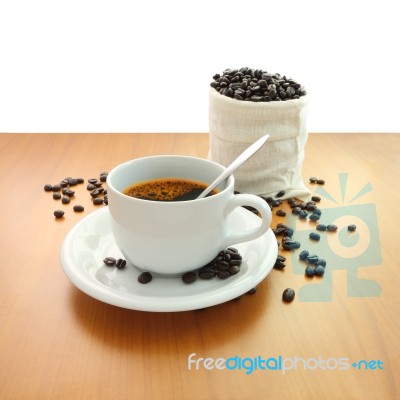 Cup Of Coffee And Bag Beans On Wooden Table White Background Stock Photo