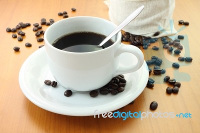 Cup Of Coffee And Part Bag Beans On Wooden Table Stock Photo