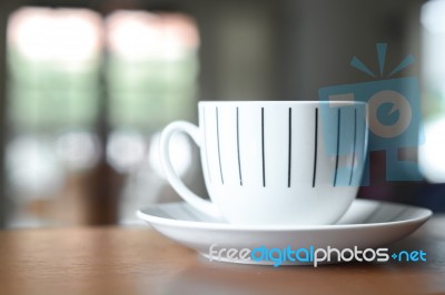 Cup Of Coffee On A Wooden Desk And Living Room Background Stock Photo