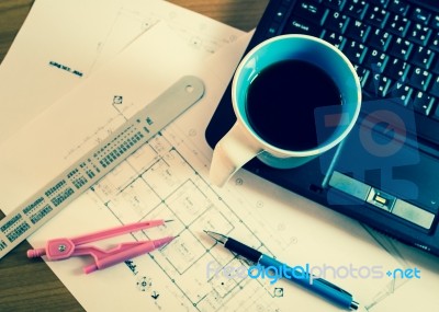 Cup Of Coffee On Laptop With Construction Plans Stock Photo