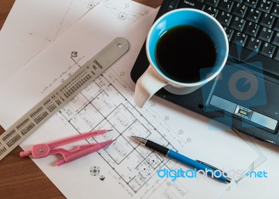 Cup Of Coffee On Laptop With Construction Plans Stock Photo