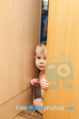 Curious Cute Baby Boy Looking Through Ajar Door Stock Photo