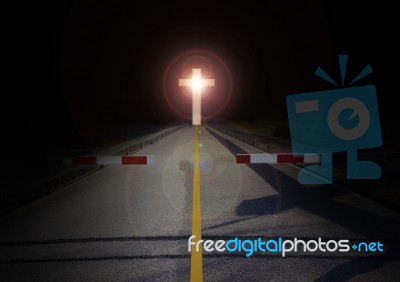 Cut Barrier On Road With Crucifix Light In Darkness Stock Photo