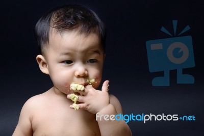 Cute Asian Baby Eating Cake With His Hand Stock Photo