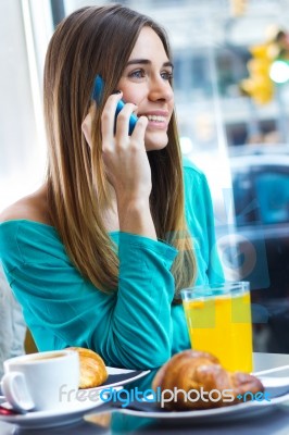 Cute Brunette Woman In Cafe Is Speaking By Mobile Phone Stock Photo