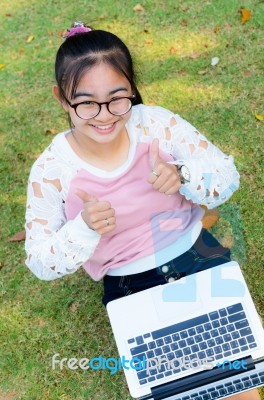 Cute Girl Is Happy With Notebook On Grass Stock Photo