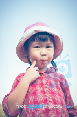 Cute Little Asian Girl Eating A Lollipop On Nature Background In… Stock Photo