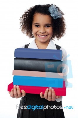 Cute School Girl Carrying Stack Of Books Stock Photo