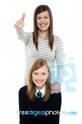 Cute Schoolgirl With Her Mom. Mother Gesturing Thumbs Up Stock Photo