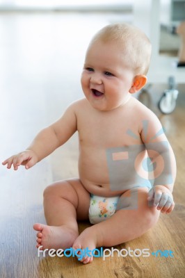 Cute Smiling Baby Sitting At Home Stock Photo