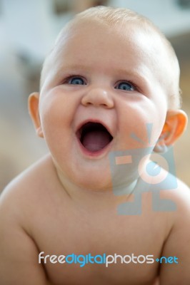 Cute Smiling Baby Sitting At Home Stock Photo