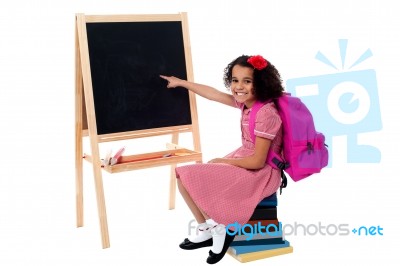 Cute Smiling Student Pointing At Blank Chalkboard Stock Photo