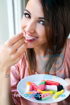 Cute Young Woman Eating Jelly Candies With A Fresh Smile Stock Photo