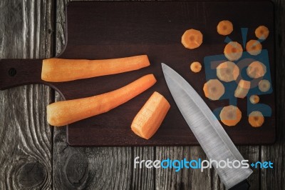 Cutting Carrots On The Wooden Board Top View Stock Photo