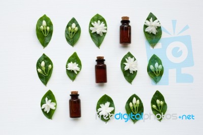 Dark Brown Bottles Of Essential Oil With Jasmine Flower Stock Photo