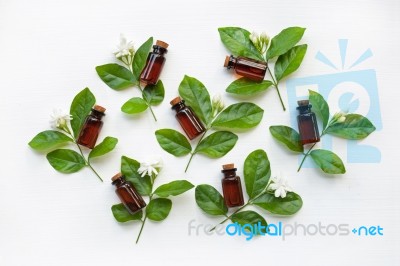 Dark Brown Bottles Of Essential Oil With Jasmine Flower Stock Photo