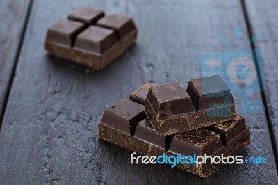 Dark Chocolate Pieces On Wooden Table Background Stock Photo