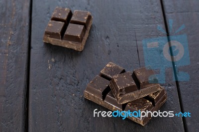 Dark Chocolate Pieces On Wooden Table Background Stock Photo