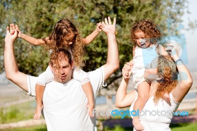 Daughters On Parents Shoulders Stock Photo