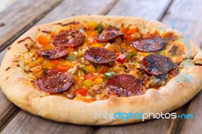 Delicious Baked Salami Pizza Served On Rustic Wooden Table Stock Photo