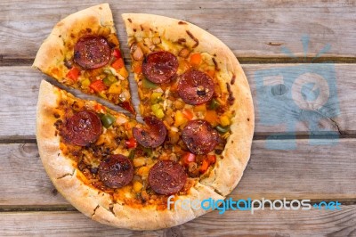 Delicious Baked Salami Pizza Served On Rustic Wooden Table Stock Photo