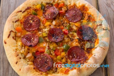 Delicious Baked Salami Pizza Served On Rustic Wooden Table Stock Photo