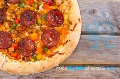 Delicious Baked Salami Pizza Served On Rustic Wooden Table Stock Photo