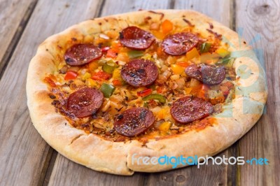 Delicious Baked Salami Pizza Served On Rustic Wooden Table Stock Photo