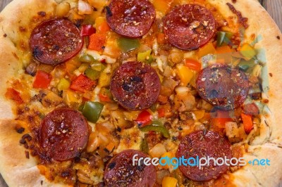 Delicious Baked Salami Pizza Served On Rustic Wooden Table Stock Photo