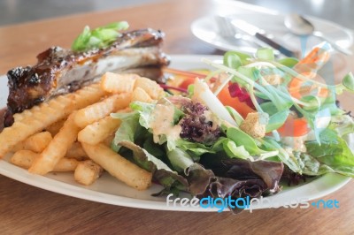 Delicious Barbecued Ribs With Spicy Sauce And Organic Salad Stock Photo