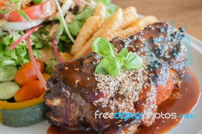 Delicious Barbecued Ribs With Spicy Sauce And Organic Salad Stock Photo