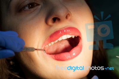 Dentist Curing A Female Patient Stock Photo