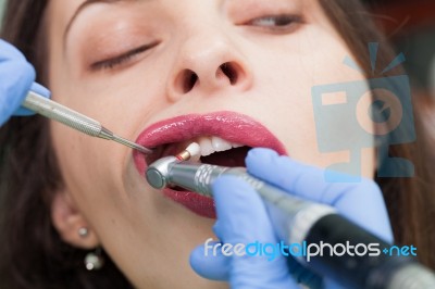 Dentist Curing A Female Patient Stock Photo