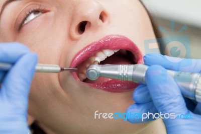 Dentist Curing A Female Patient Stock Photo