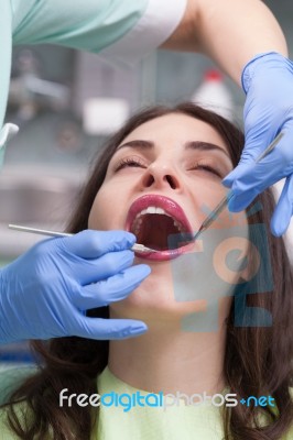 Dentist Curing A Female Patient Stock Photo