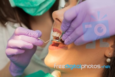 Dentist Examining A Patient's Teeth In The Dentist Stock Photo