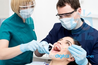 Dentist Examining Gums Of Patient Stock Photo